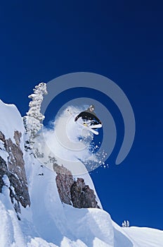 Skier Jumping From Mountain Ledge photo