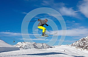 Skier jumps in snow park against the blue sky