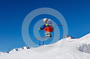 Skier jumps in snow park against the blue sky in Livigno ski resort, Italy