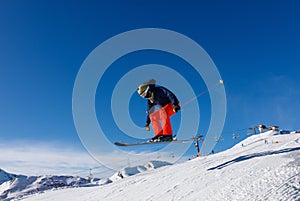 Skier jumps in snow park against the blue sky in Livigno ski resort, Italy