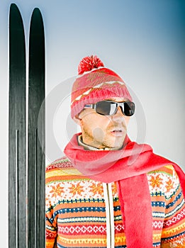 Skier in knitted wool dress with ornament and sunglasses