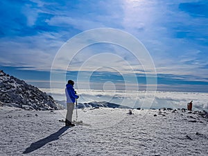 Skier looking at the beautiful landscape on the mountain top.