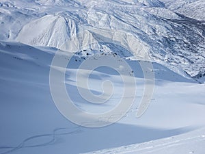 Skier making fresh tracks in the untouched snow down a valley