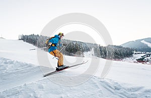 Skier man at jump from the slope of mountains