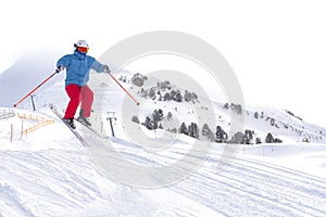 Skier man with orange ski glasses in white helmet make release jump on ski slope on top in Alps mountains. On the background of