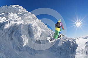 Skier on monoski in high mountains against blue sky