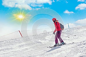 Skier in mountains, prepared piste and sunny day