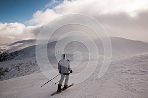 Skier in mountains, prepared piste and sunny day