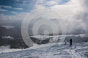 Skier in mountains, prepared piste and sunny day