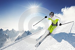 Skier in mountains, prepared piste and sunny day photo