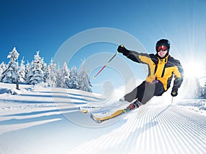 Skier in mountains, prepared piste and sunny day