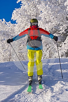 Skier in mountains, prepared piste and sunny day. winter, leisure, sport and people concept