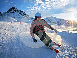 Skier on piste in high mountains with beautiful sky on sunny day