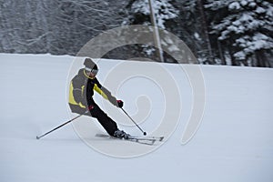 Skier on piste running downhill