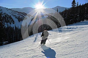 Skier on a piste under a setting sun