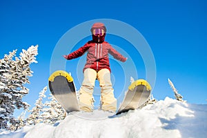 Skier is preparing for jump, lower angle of ski, blue sky winter forest