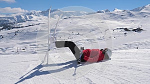 Skier Resting In The Mountains Lying On The Snow And Legs Up With Skis