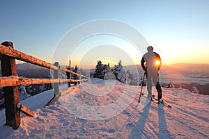 A skier is resting at a ski resort with beautiful view to the snowy mountains.