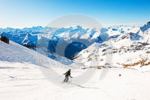 Skier rides down the slope in Alps mountains. Val Thorens, France