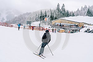 Skier rides, leaning sideways, along a snowy slope at the Kolasin 1600 ski resort. Montenegro. Back view