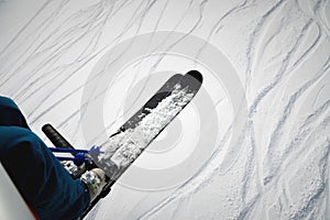 A skier sits on a chair lift on a beautiful day, Alpine mountains. Skiing concept. Side view of a skier on the ski lift