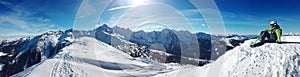 Skier sitting on top of a mountain