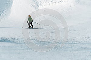 Skier on the ski slope skiing downhill