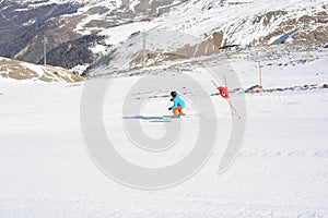 Skier skiing dowhill race on the piste in the mountains. Alps in winter.