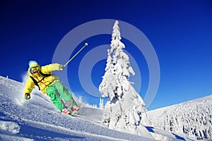 Skier skiing downhill in high mountains