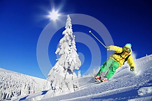 Skier skiing downhill in high mountains