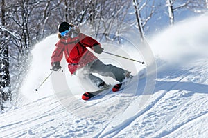 Skier skiing downhill in high mountains