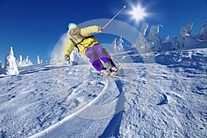 Skier skiing downhill in high mountains