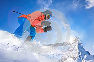 Skier skiing downhill in high mountains against Matterhorn peak in Swiss Alps