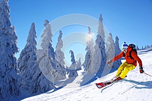 Skier skiing downhill in high mountains against sunset photo