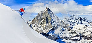 Skier skiing downhill in high mountains in fresh powder snow. Sn photo