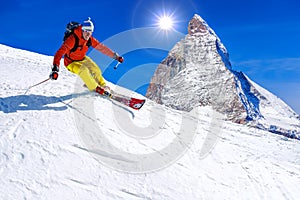 Skier skiing downhill in high mountains, Matterhorn, Switzerland