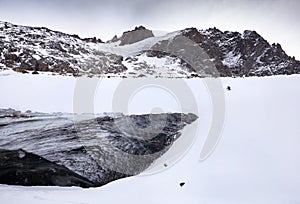 Skier skiing downhill in high snowy mountains