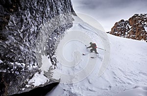 Skier skiing downhill in high snowy mountains