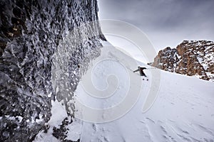 Skier skiing downhill in high snowy mountains