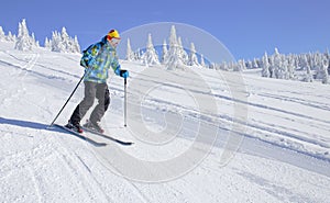 Skier skiing downhill on ski slope