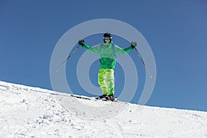 Skier skiing downhill during sunny day in high mountains