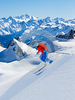 Skier skiing downhill Valle Blanche in french Alps in fresh powder snow. Snow mountain range Mont Blanc with Grand Jorasses in ba photo