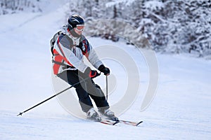 Skier skiing downhill in winter mountains