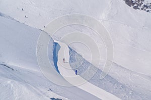 Skier skiing with helmet alone on the ski slope towards Matterhorn mountain on a beautiful sunny day in Switzerland