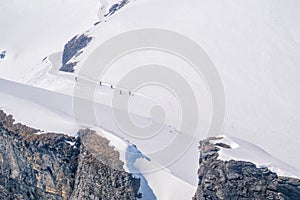 Skier skiing with helmet alone on the ski slope towards Matterhorn mountain on a beautiful sunny day in Switzerland