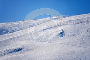 Skier skiing with helmet alone on the ski slope towards Matterhorn mountain on a beautiful sunny day in Switzerland