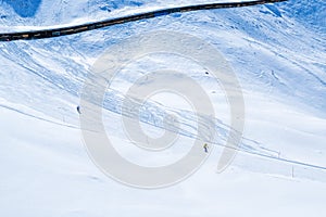 Skier skiing with helmet alone on the ski slope towards Matterhorn mountain on a beautiful sunny day in Switzerland