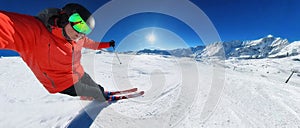 Skier skiing on a sunny day in high mountains on ski slope