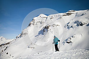 A skier on slope in alpine ski resort