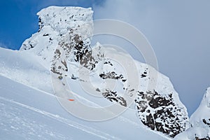 Skier spraying soft powdery snow among volcanic peak in the backcountry near Niseko, Japan